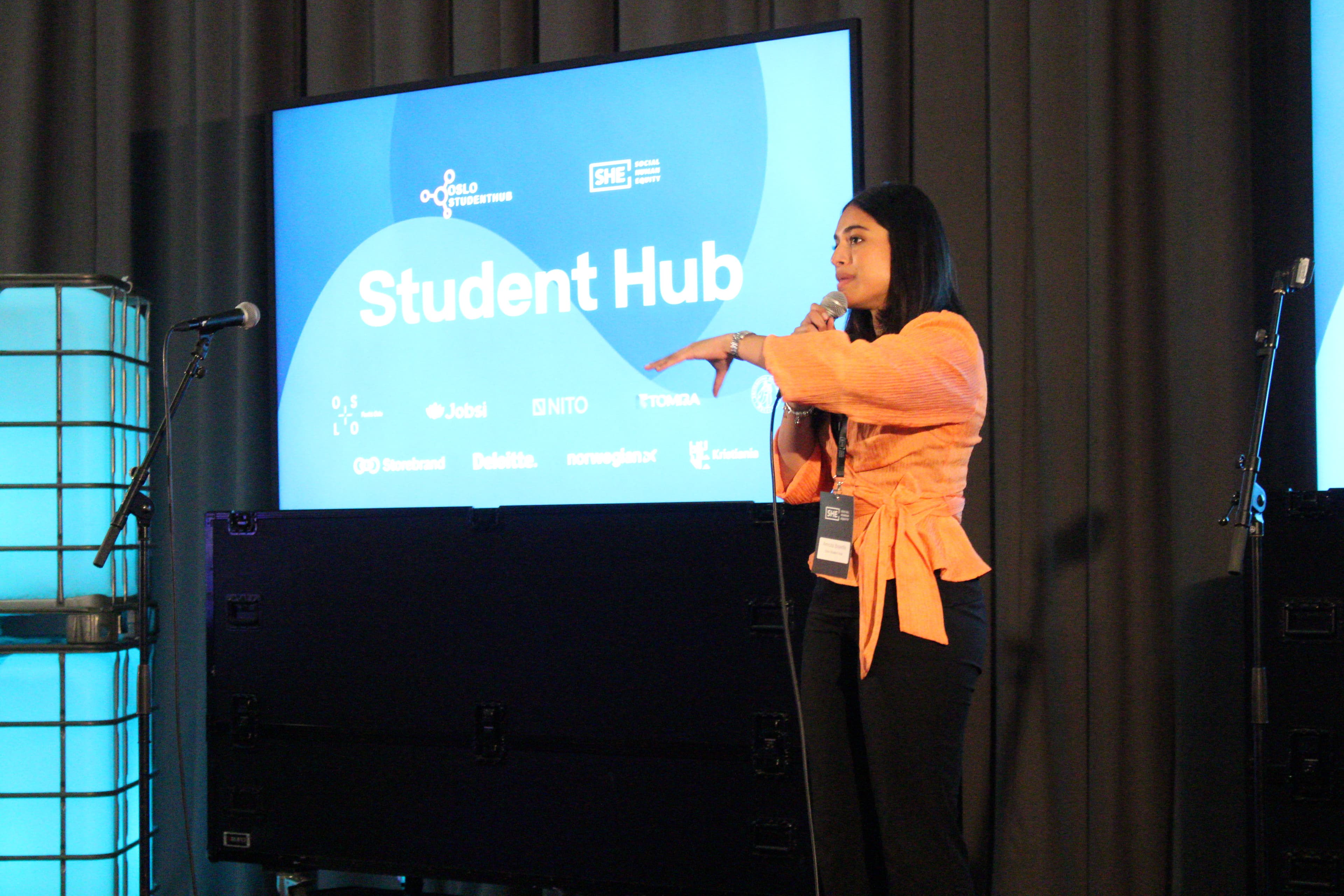An Oslo Student Hub speaker presenting on stage.